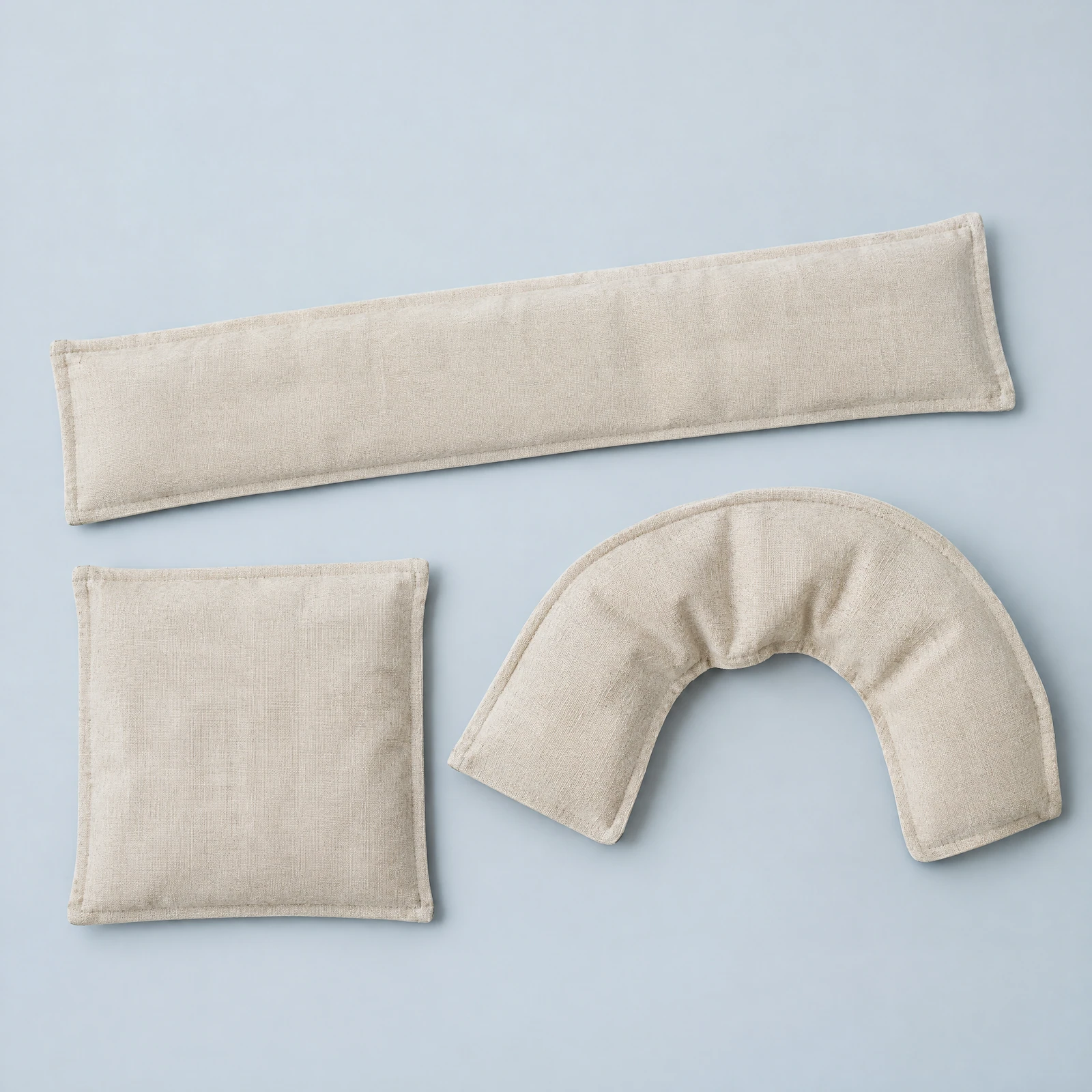Three oatmeal-colored padded wraps in long, square and curved neck shapes